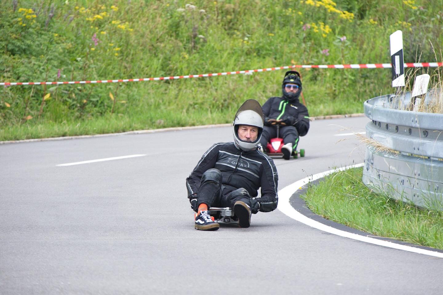 After weeks and months of intense planning, organizing and preparing it finally happened: For the first time in downhill skating history we closed down our Freiburg house mountain, Schauinsland, for a downhill skateboarding Freeride event. Considering it (one of) the longest event tracks ever, it presented us with immense safety challenges to clear and secure a 12km road. This put our meticulously designed safety concept on the test bench.
.
We wanted to start right after the bicycle event and we were right on time when the weather decided otherwise. Half an hour of intense thunder and hailstorm left our riders fleeing into the woods and some of our stationary Marshalls putting up there shelter pavilions in the middle of the raging chaos.
.
So with a small delay and some wet clothes we were able to start the Freeride. Of course we had multiple difficulties in the following hours but our well trained Marshall team and @studio.konstantin.thomas as our head of radio communications with nerves of steel, handled every demanding situation with calm and professionalism.
.
Seeing our riders lifting up there helmet visors revealing smiling happy faces underneath rewarded us every run.
.
In the last picture you see me skating through the last hairpin during the bonus run as the last rider of the event which felt like a true honor and perfect closing to an overall successful and injury-free event.
.
.
📸 1,2,4,5,8,9,10,11,13,14,15 Henning Stark
📸 3,6,7,12 @photoluky
📸 16 @klangreiter
📸 17,18,19 @fla4.2
📸 20 @speedy_gonzales_77
.
.
#worldsfirst #downinsländ2025 #schauinsland #freiburgfreeridecrew #freiburgerlongboardverein #flbv #skateevent #12km #gondolafreeride #downhillskateboarding #downhilllongboarding #makedhskatinggreatagain #communitybuilding