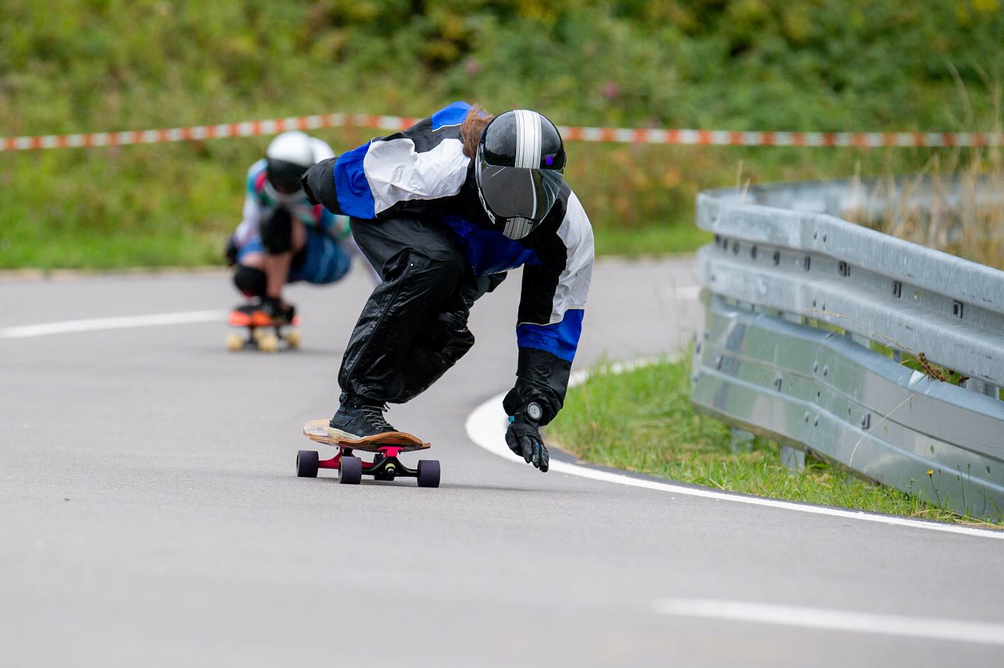 After weeks and months of intense planning, organizing and preparing it finally happened: For the first time in downhill skating history we closed down our Freiburg house mountain, Schauinsland, for a downhill skateboarding Freeride event. Considering it (one of) the longest event tracks ever, it presented us with immense safety challenges to clear and secure a 12km road. This put our meticulously designed safety concept on the test bench.
.
We wanted to start right after the bicycle event and we were right on time when the weather decided otherwise. Half an hour of intense thunder and hailstorm left our riders fleeing into the woods and some of our stationary Marshalls putting up there shelter pavilions in the middle of the raging chaos.
.
So with a small delay and some wet clothes we were able to start the Freeride. Of course we had multiple difficulties in the following hours but our well trained Marshall team and @studio.konstantin.thomas as our head of radio communications with nerves of steel, handled every demanding situation with calm and professionalism.
.
Seeing our riders lifting up there helmet visors revealing smiling happy faces underneath rewarded us every run.
.
In the last picture you see me skating through the last hairpin during the bonus run as the last rider of the event which felt like a true honor and perfect closing to an overall successful and injury-free event.
.
.
📸 1,2,4,5,8,9,10,11,13,14,15 Henning Stark
📸 3,6,7,12 @photoluky
📸 16 @klangreiter
📸 17,18,19 @fla4.2
📸 20 @speedy_gonzales_77
.
.
#worldsfirst #downinsländ2025 #schauinsland #freiburgfreeridecrew #freiburgerlongboardverein #flbv #skateevent #12km #gondolafreeride #downhillskateboarding #downhilllongboarding #makedhskatinggreatagain #communitybuilding