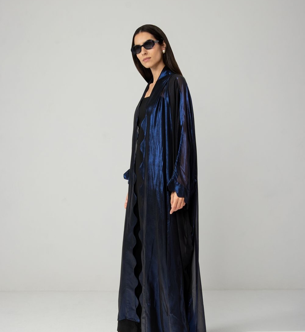 The Wavy Shimmers Abaya is made from shimmering chiffon that beautifully reflects the light adding a touch of fluidity and movement to the design.