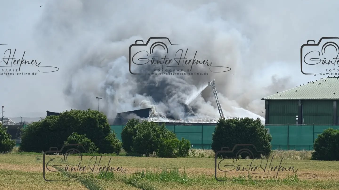 Lagerhalle von Recyclingbetrieb Wurzer brennt: Großaufgebot im Einsatz
🗓️Datum: 28.06.2026
⏰Uhrzeit: 10:21 Uhr
🚒🚑 Einsatzart: B 4
📍Einsatzort: Eitting
🚒🚑🚁🚓 Eingesetzte Kräfte:
Eine Lagerhalle ist in Brand geraten. Mehrere Feuerwehren bekämpfen den Brand mit starker Rauchentwicklung seit Stunden. Eine Warnmeldung an die Eittinger Bevölkerung ging raus.
Eitting – Eine Lagerhalle des Recyclingbetriebs Wurzer in Eitting ist am Sonntagvormittag gegen 10.20 Uhr in Brand geraten. Einsatzkräfte mehrerer Feuerwehren sind mit einem Großaufgebot vor Ort und bekämpfen das Feuer. Es kommt derzeit zu starker Rauchentwicklung.
Laut einem Sprecher des Polizeipräsidiums Oberbayern-Nord war am Sonntagvormittag gegen 10.20 Uhr Müll in einer Lagerhalle in Brand geraten, „und im Folgenden wohl auch die Lagerhalle selbst“. Über die Größe der Halle sowie Ausmaß des Schadens könne er noch keine Auskünfte geben. Verletzte habe es durch den Brand nicht gegeben. Aber aufgrund der sehr starken Rauchentwicklung in Richtung Osten „haben wir gerade vor ein paar Minuten auch noch über unsere Social Media Accounts Warnungen für die Bevölkerung in Eitting ausgesteuert“, sagte der Sprecher am Sonntag gegen 14.30 Uhr. „Sicherheit geht einfach vor. Man weiß ja nicht, was da genau in Brand geraten ist.“ Wegen der Brandursache werde noch ermittelt.
Wegen der Brandursache werde noch ermittelt. Dem Vernehmen nach soll eine Halle einsturzgefährdet gewesen sein und das Feuer auf ein weiteres Gebäude übergegriffen haben. Ein Sprecher der Firma Wurzer war am Sonntag nicht erreichbar.
Für die Feuerwehren war der Einsatz angesichts der ohnehin hohen Temperaturen eine ganz besondere Herausforderung. So war zu hören, dass die enorme körperliche Belastung für mehrere Einsatzkräfte zu viel wurde. Sie mussten selbst behandelt werden.
Bei Temperaturen um die 40 Grad kamen die vielen Atemschutzgeräteträger an ihr Limit: Mit rund 25 Kilogramm schweren Pressluftflaschen und in voller Montur gaben sie alles, um das Feuer schnellstmöglich unter Kontrolle zu bringen, sagt Sebastian Brendel, Pressesprecher der Kreisbrandinspektion Freising.
Quelle: Merkur online
📷 Günter Herkner