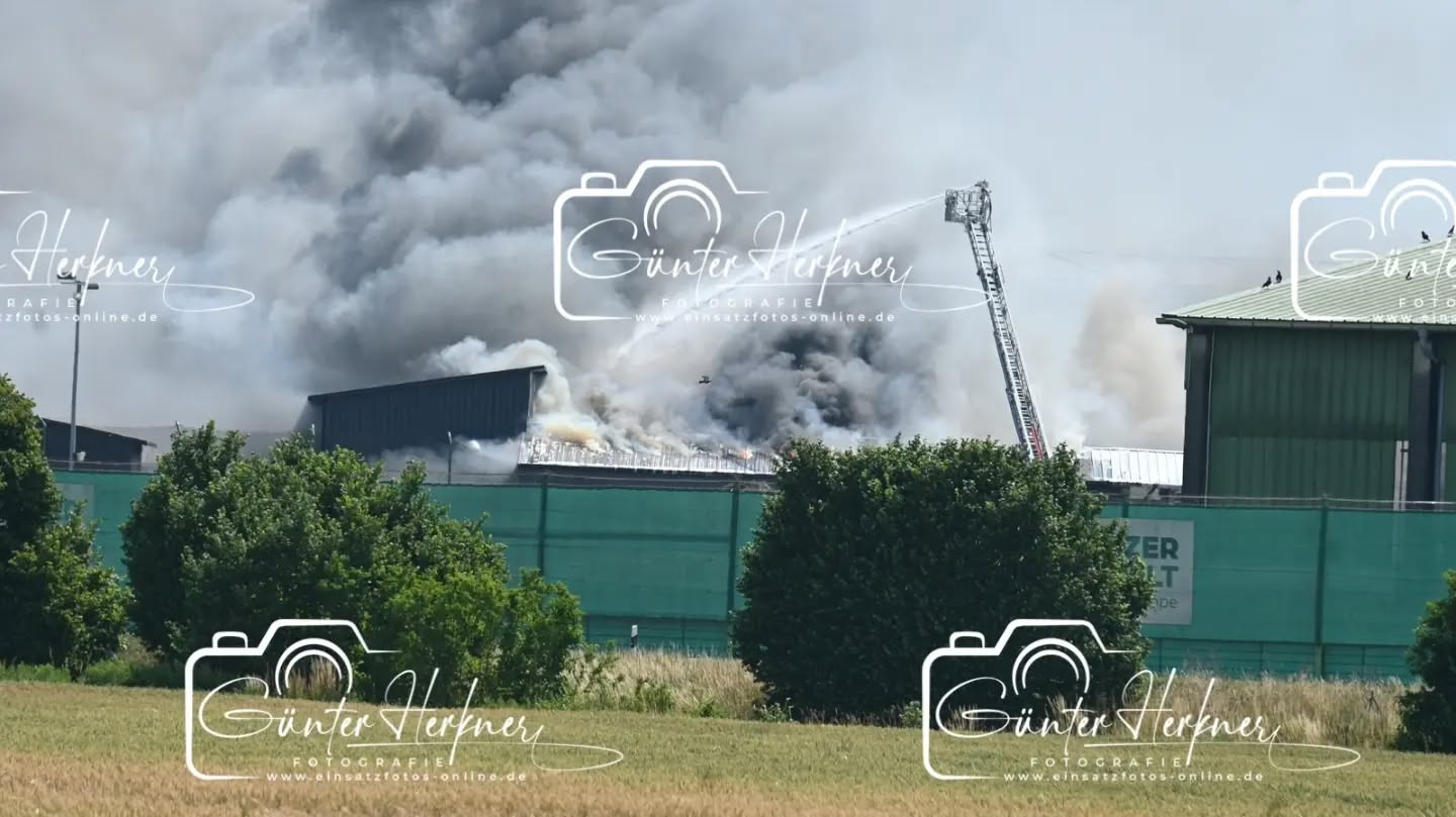Lagerhalle von Recyclingbetrieb Wurzer brennt: Großaufgebot im Einsatz
🗓️Datum: 28.06.2026
⏰Uhrzeit: 10:21 Uhr
🚒🚑 Einsatzart: B 4
📍Einsatzort: Eitting
🚒🚑🚁🚓 Eingesetzte Kräfte:
Eine Lagerhalle ist in Brand geraten. Mehrere Feuerwehren bekämpfen den Brand mit starker Rauchentwicklung seit Stunden. Eine Warnmeldung an die Eittinger Bevölkerung ging raus.
Eitting – Eine Lagerhalle des Recyclingbetriebs Wurzer in Eitting ist am Sonntagvormittag gegen 10.20 Uhr in Brand geraten. Einsatzkräfte mehrerer Feuerwehren sind mit einem Großaufgebot vor Ort und bekämpfen das Feuer. Es kommt derzeit zu starker Rauchentwicklung.
Laut einem Sprecher des Polizeipräsidiums Oberbayern-Nord war am Sonntagvormittag gegen 10.20 Uhr Müll in einer Lagerhalle in Brand geraten, „und im Folgenden wohl auch die Lagerhalle selbst“. Über die Größe der Halle sowie Ausmaß des Schadens könne er noch keine Auskünfte geben. Verletzte habe es durch den Brand nicht gegeben. Aber aufgrund der sehr starken Rauchentwicklung in Richtung Osten „haben wir gerade vor ein paar Minuten auch noch über unsere Social Media Accounts Warnungen für die Bevölkerung in Eitting ausgesteuert“, sagte der Sprecher am Sonntag gegen 14.30 Uhr. „Sicherheit geht einfach vor. Man weiß ja nicht, was da genau in Brand geraten ist.“ Wegen der Brandursache werde noch ermittelt.
Wegen der Brandursache werde noch ermittelt. Dem Vernehmen nach soll eine Halle einsturzgefährdet gewesen sein und das Feuer auf ein weiteres Gebäude übergegriffen haben. Ein Sprecher der Firma Wurzer war am Sonntag nicht erreichbar.
Für die Feuerwehren war der Einsatz angesichts der ohnehin hohen Temperaturen eine ganz besondere Herausforderung. So war zu hören, dass die enorme körperliche Belastung für mehrere Einsatzkräfte zu viel wurde. Sie mussten selbst behandelt werden.
Bei Temperaturen um die 40 Grad kamen die vielen Atemschutzgeräteträger an ihr Limit: Mit rund 25 Kilogramm schweren Pressluftflaschen und in voller Montur gaben sie alles, um das Feuer schnellstmöglich unter Kontrolle zu bringen, sagt Sebastian Brendel, Pressesprecher der Kreisbrandinspektion Freising.
Quelle: Merkur online
📷 Günter Herkner