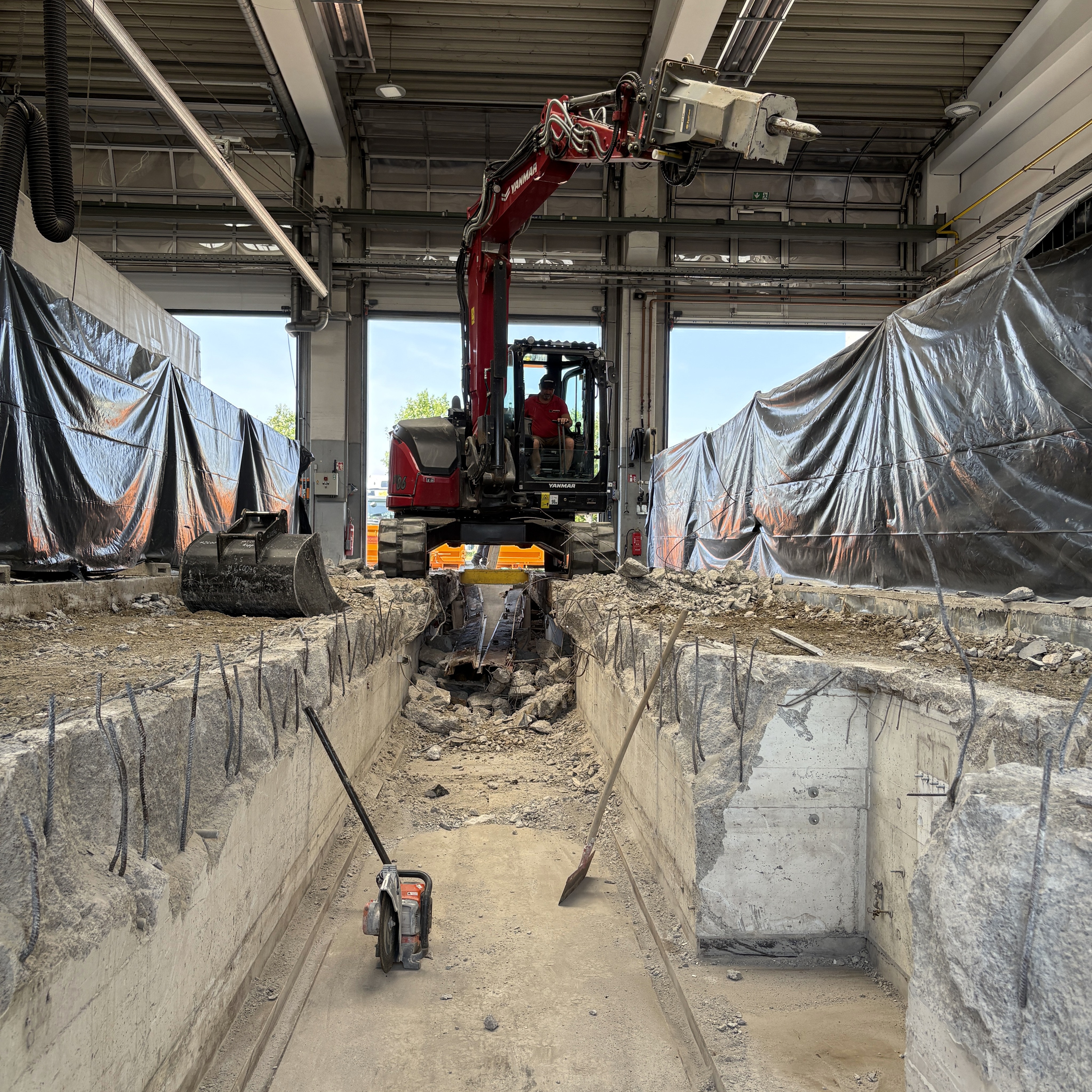 In einer großen LKW-Werkstatt hatten wir den Auftrag, 2 in die Jahre gekommene Arbeitsgruben zu sanieren, hier gab es bereits Abplatzungen und Ausbrüche an der Einfassung. Um dennoch während der Sanierungsarbeiten den eigentlichen Betrieb aufrecht erhalten zu können, wurden die Gruben nacheinander saniert.
Die Sanierung sah folgende Schritte vor:
-Abbruch und Entfernung der bestehenden Bodenplatte inkl. dem Stahlrahmen
-liefern und einbauen eines neuen Stahlrahmens inkl. neuer Bewehrung
-Betonieren und Glätten der Bodenplatte inkl. Faserzugabe, Hartkorneinstreuung und Fugenschnitte für höhere Festigkeiten und Haltbarkeit.
-Austausch der jeweiligen Entwässerungsrinnen an der Hallenein- und Ausfahrt.
Die größte Herausforderung lag in der linearen Arbeitsweise und dem beengten Platz in der Halle. Dank Hallenkran, kompakter Betonpumpe und den umfassenden Fähigkeiten unserer Mitarbeiter sind die beiden Gruben innerhalb des vorgegebenen Zeitplans fertiggestellt worden, sodass pünktlich zum Start der Sommerferien (und somit der Hochsaison für LKW-Reparaturen) wieder voll gearbeitet werden kann.
Nach Abschluss der ersten Grube wurde natürlich als erstes eine Probebelastung mit dem Firmentransporter durchgeführt...?
Hast du auch Lust auf solche Projekte, dann bewirb dich bei uns!
#platzmangel #abbruch #sanierung #rohbau #wirkönnendas